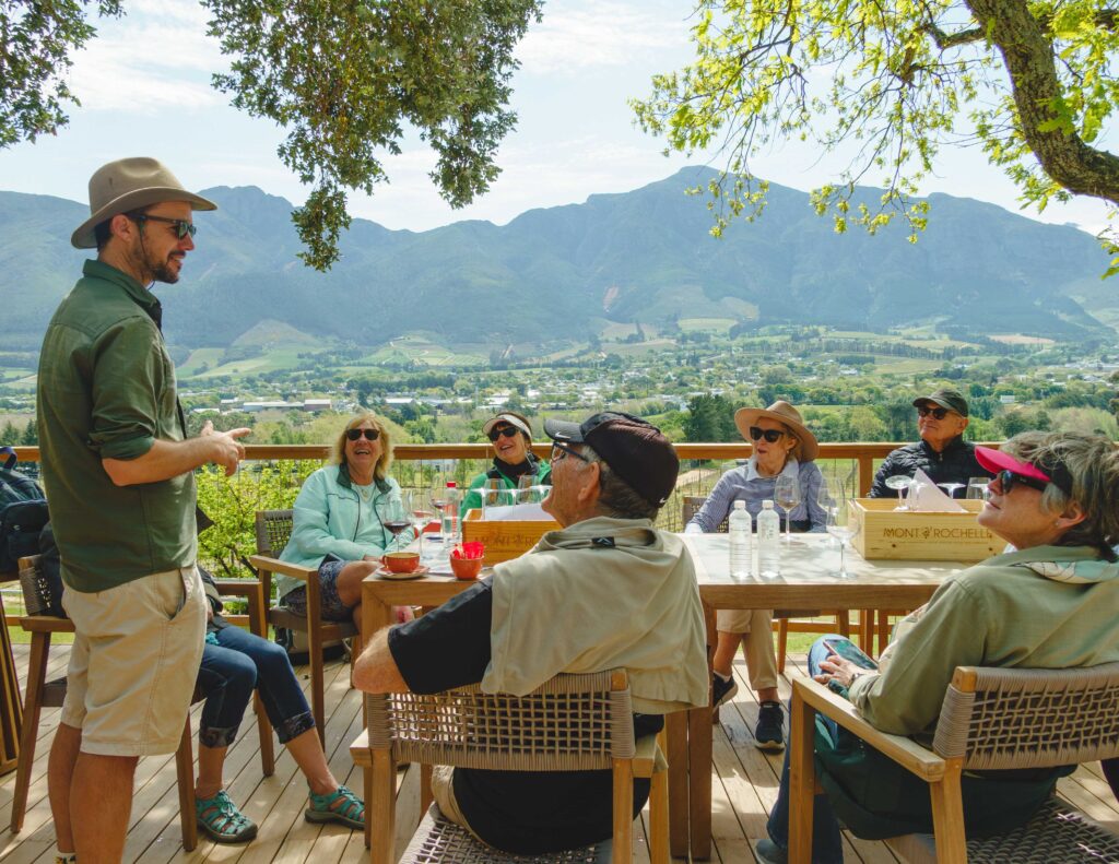 A Natural Wanders guide telling stories to guests over lunch with mountain views